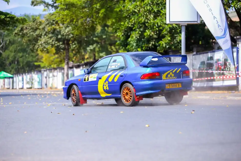 A blue rally car with graphics drifting on an open asphalt track during a daytime event.